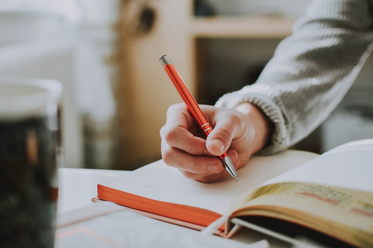 A hand marking up a manuscript with a pen